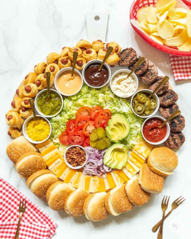 circle board with hamburger buns, patties and toppings