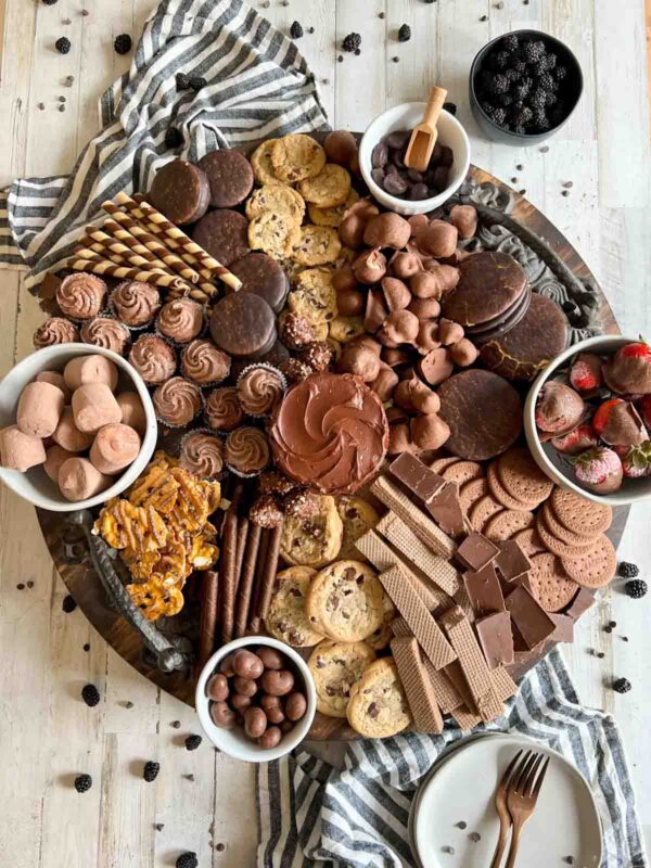circular board with cookies, strawberries and other chocolate desserts