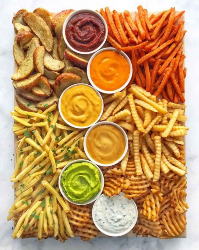 variety of french fries and dipping sauces on large tray