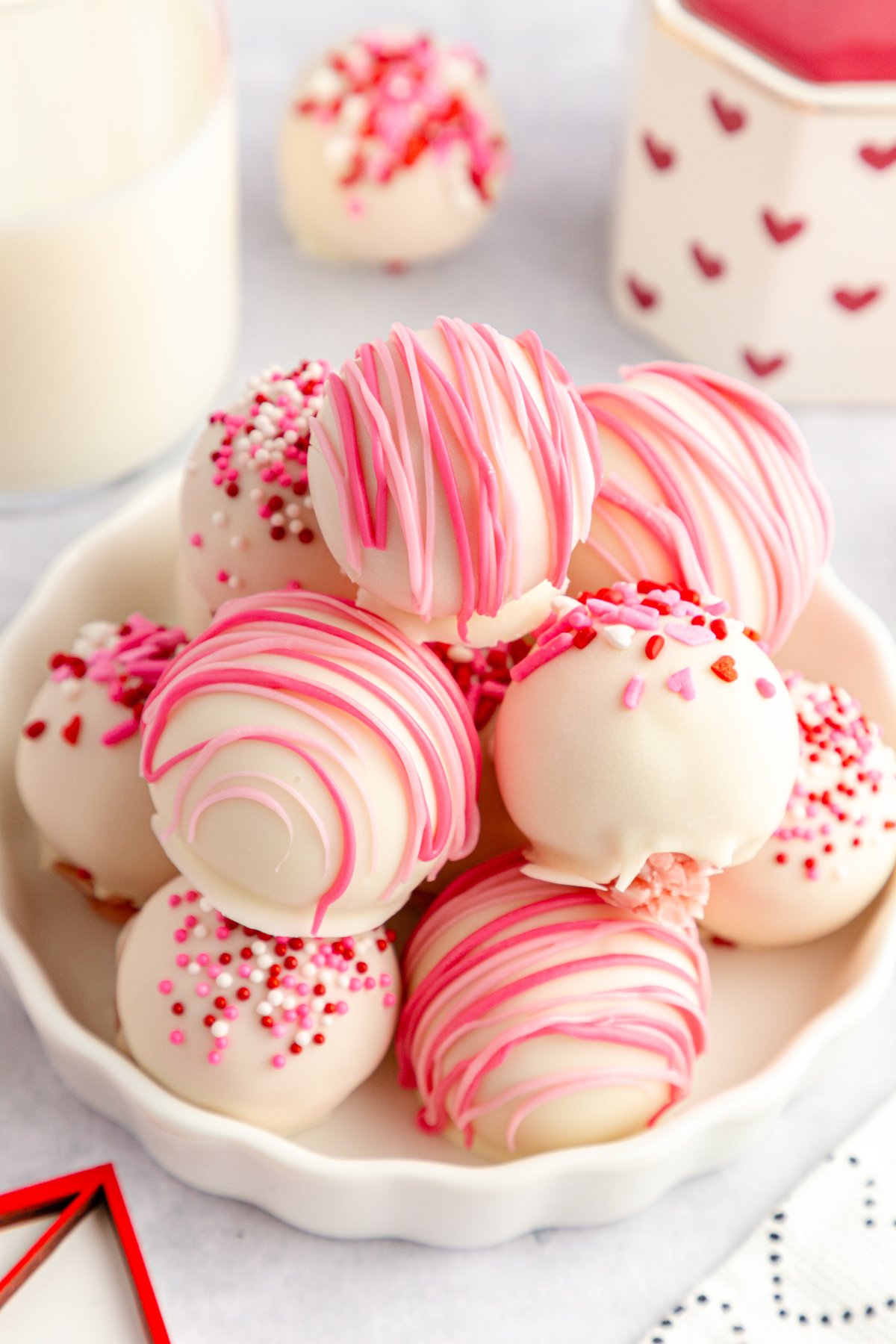 white plate with strawberry no bake cake balls in a pile