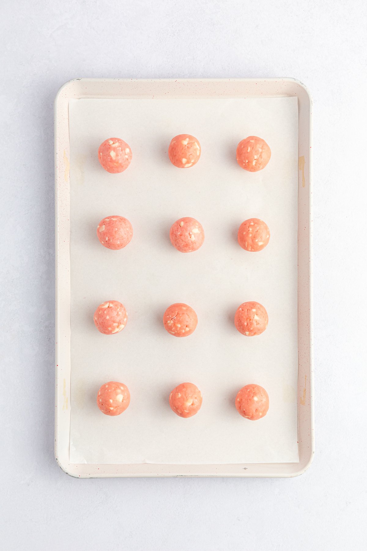 baking sheet with rolled strawberry cake mix balls