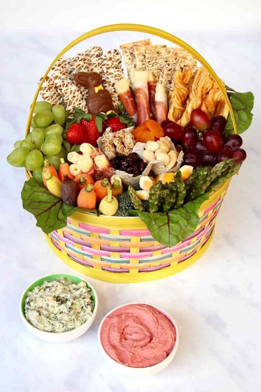easter basket filled with snack items such as carrots grapes and crackers