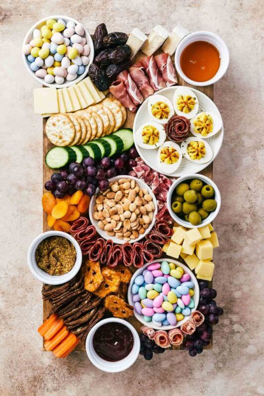 cheese and meat board with easter candy and deviled eggs