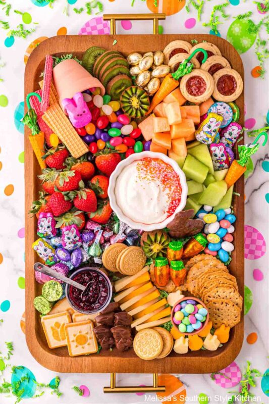 tray with fruits, dip, easter candies, cheese and crackers