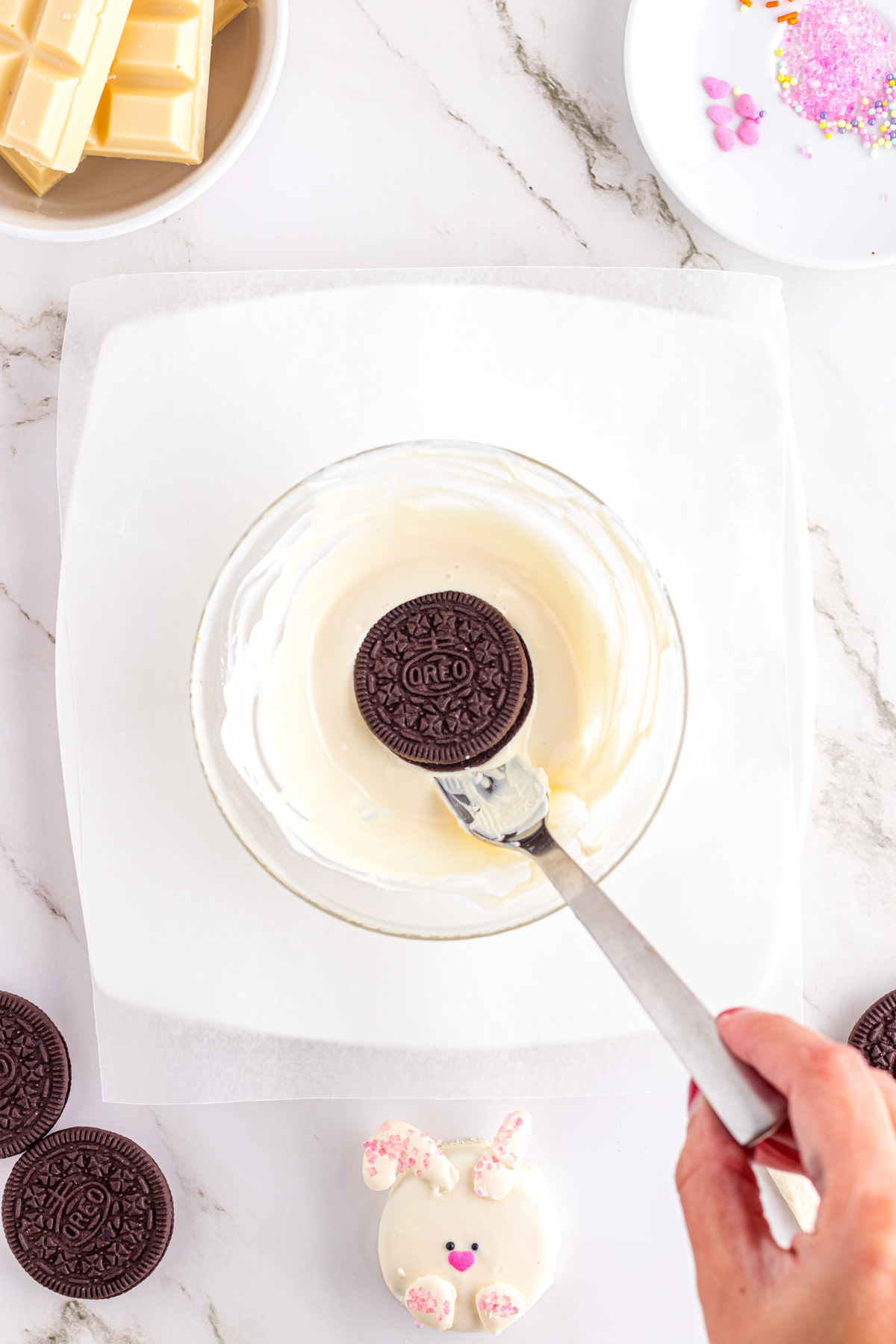Oreo on a fork above  bowl of white chocolate