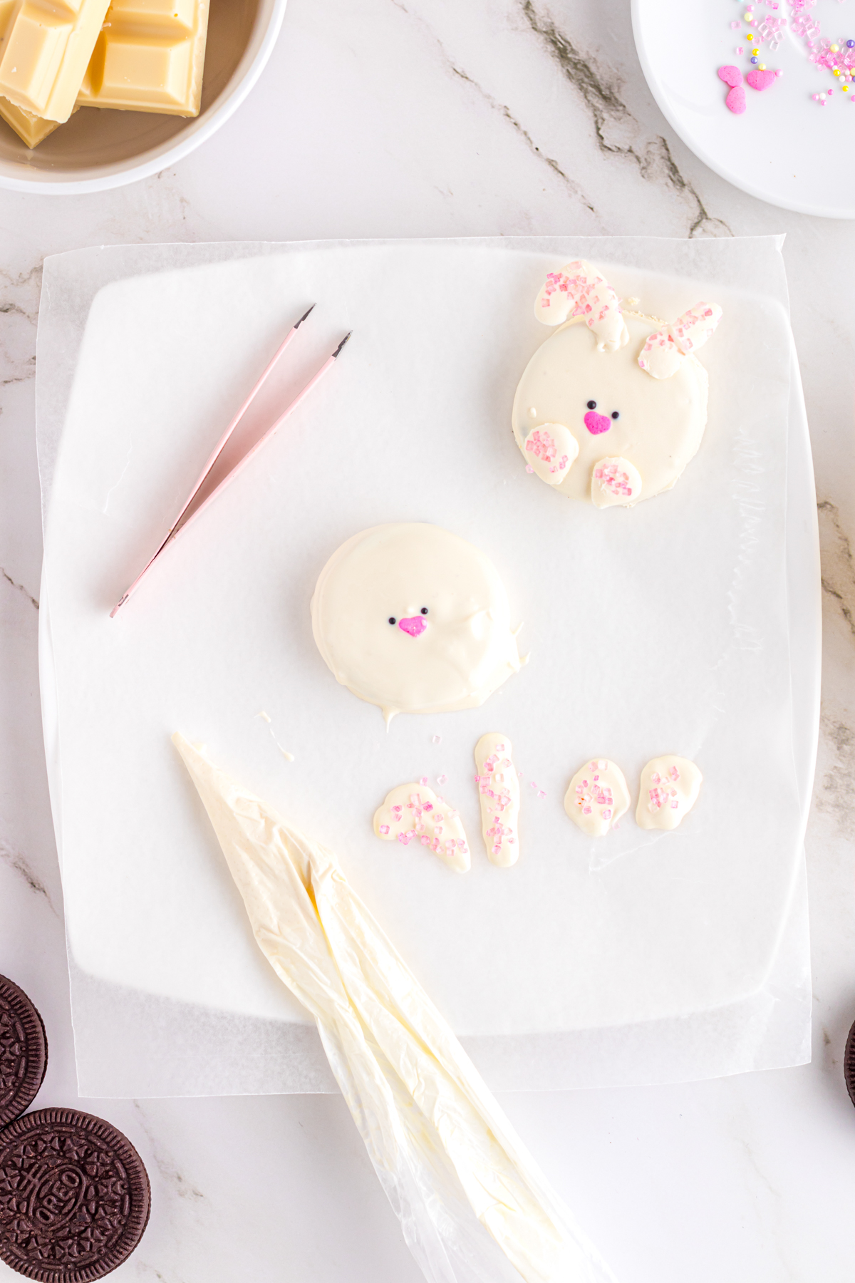 piping bag and Easter Oreos that look like bunnies on a white plate