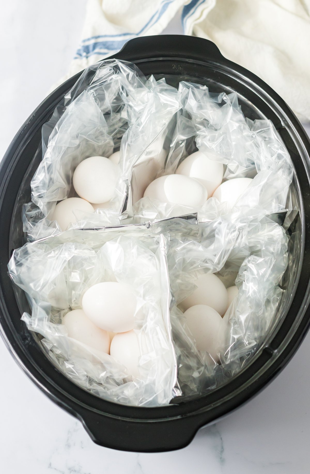 slow cooker with 16 hard boiled eggs inside