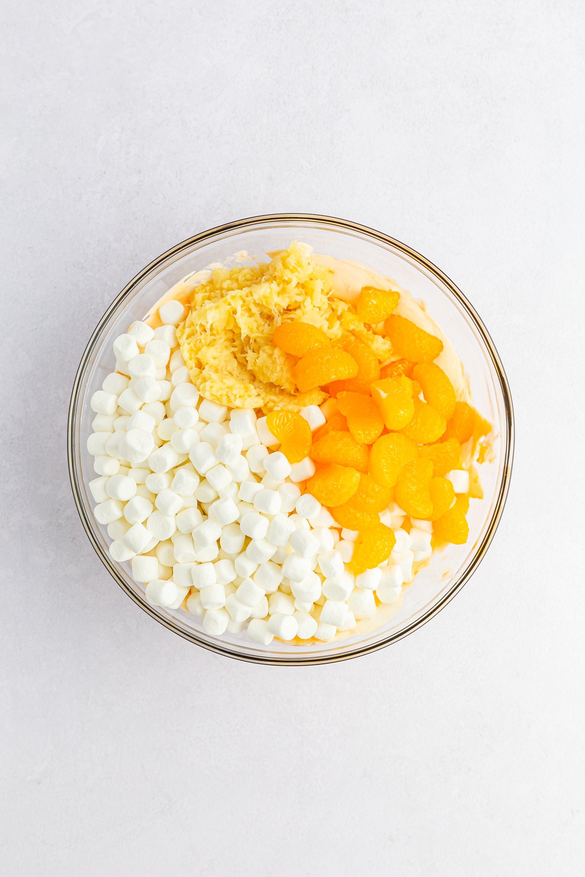 glass bowl with orange fluff salad ingredients