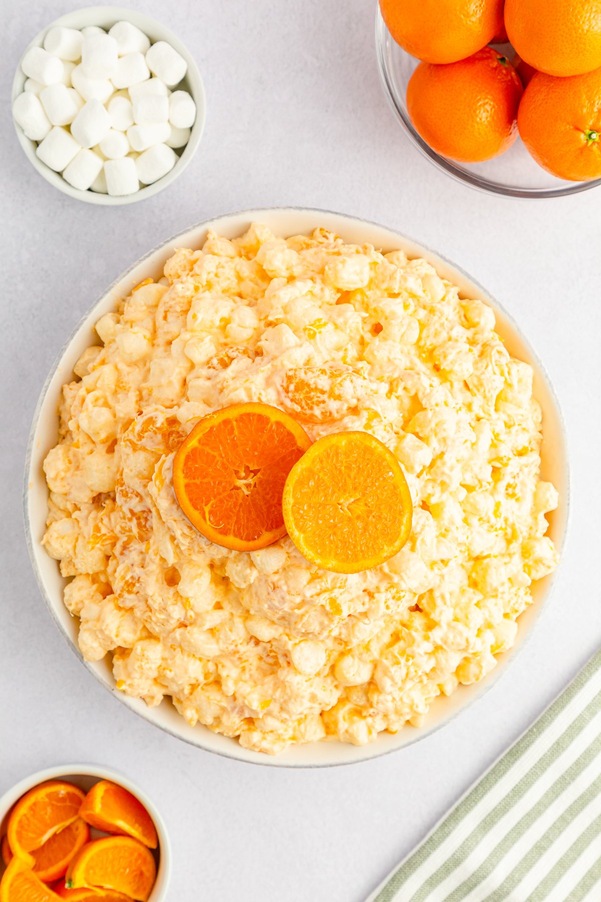 top down view of an orange fluff salad in a white bowl 