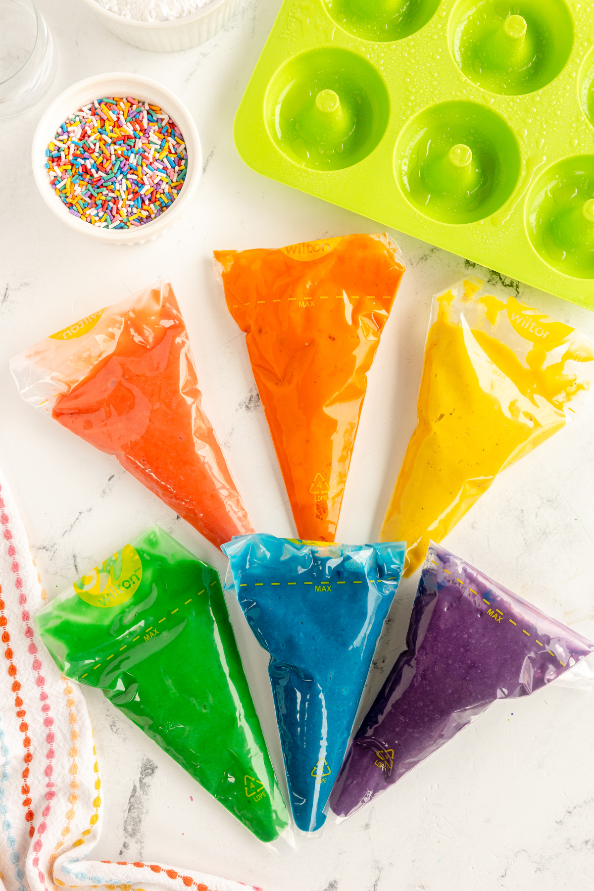 colored donut batter in piping bags