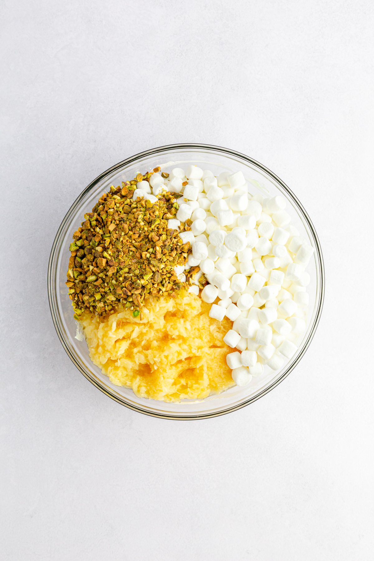 glass bowl with ingredients for pistachio salad 