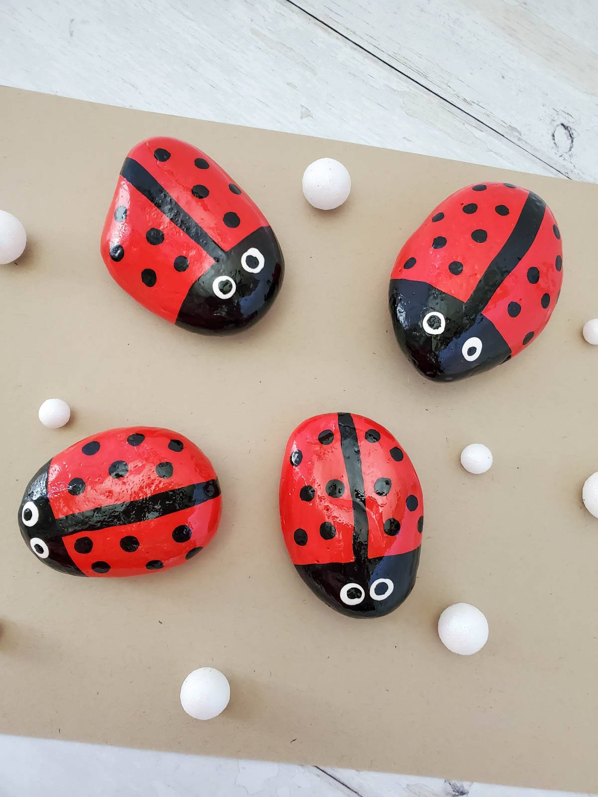 four ladybug painted rocks on a piece of brown paper