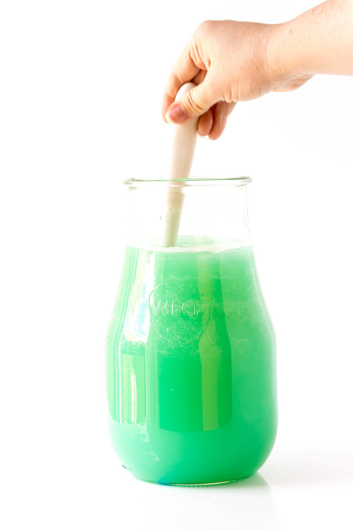 stirring mermaid punch in a glass jar
