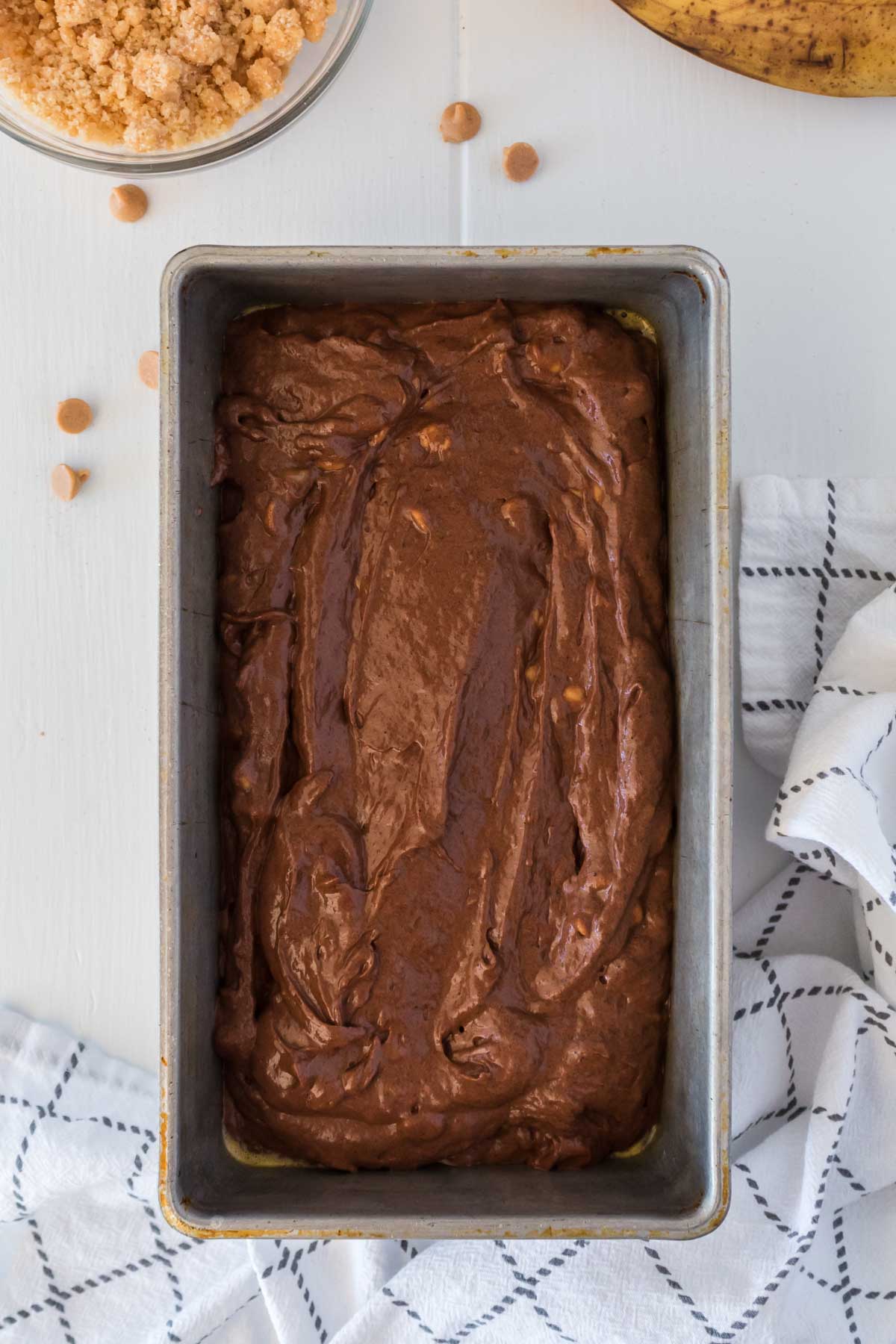 metal loaf pan with chocolate banana bread batter