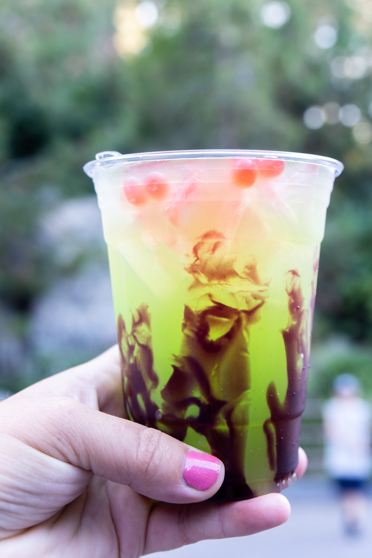 apple lemonade being held in someone's hand