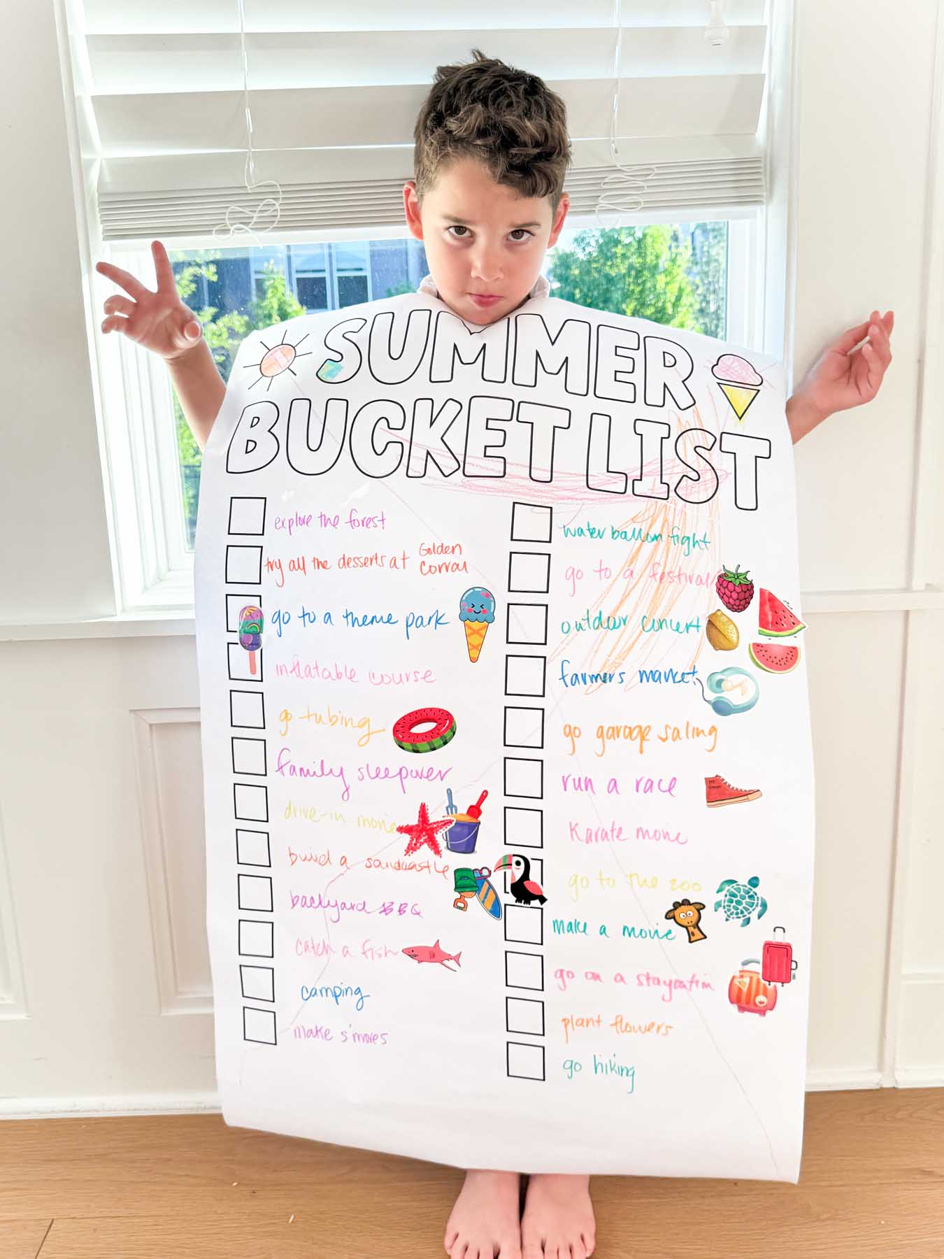 kid holding a large summer bucket list