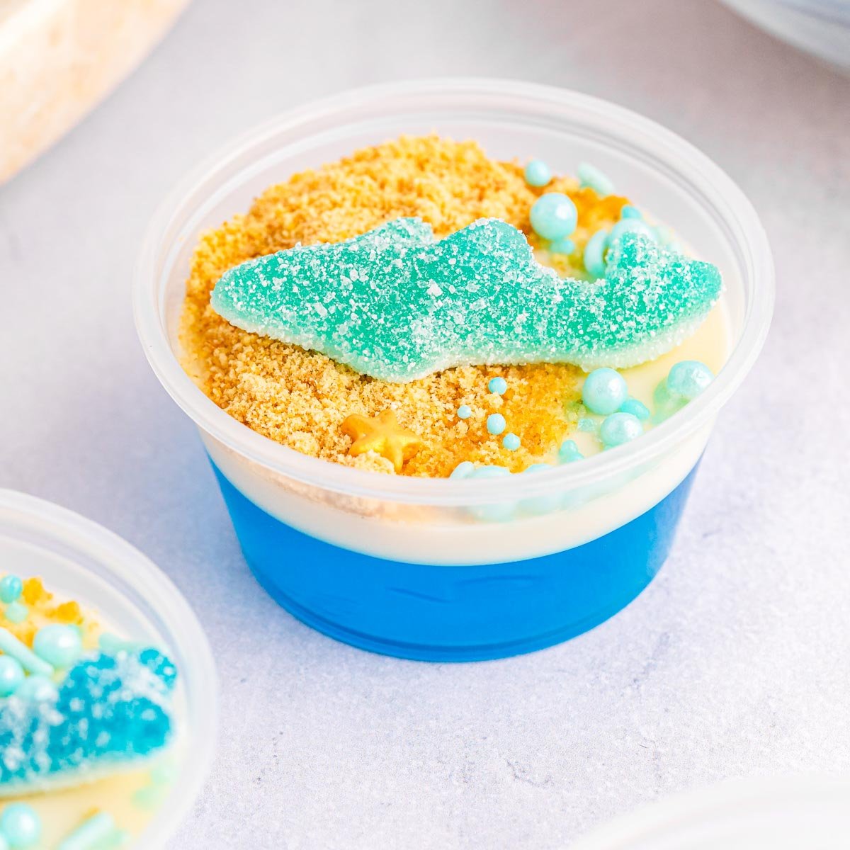 individual shark jello cups on a white table