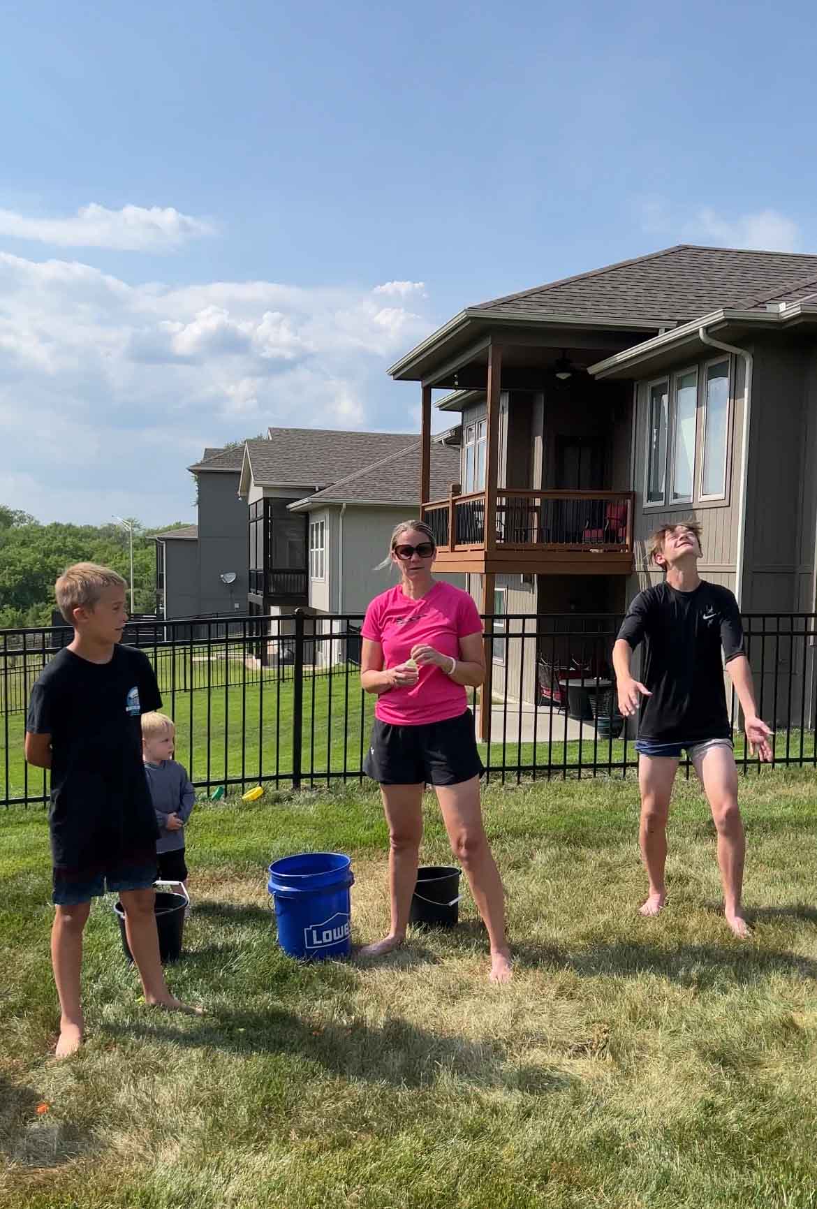 people standing by a blue bucket in backyard