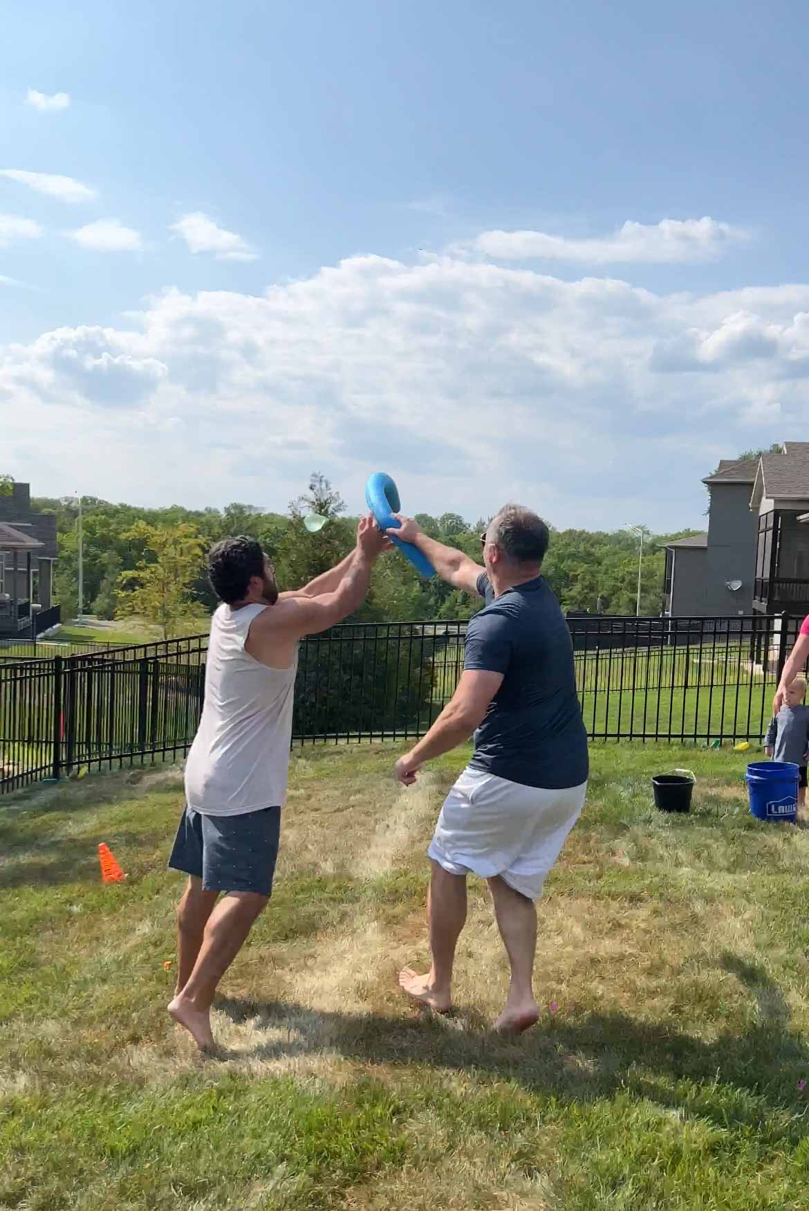 man guarding another man with a pool noodle