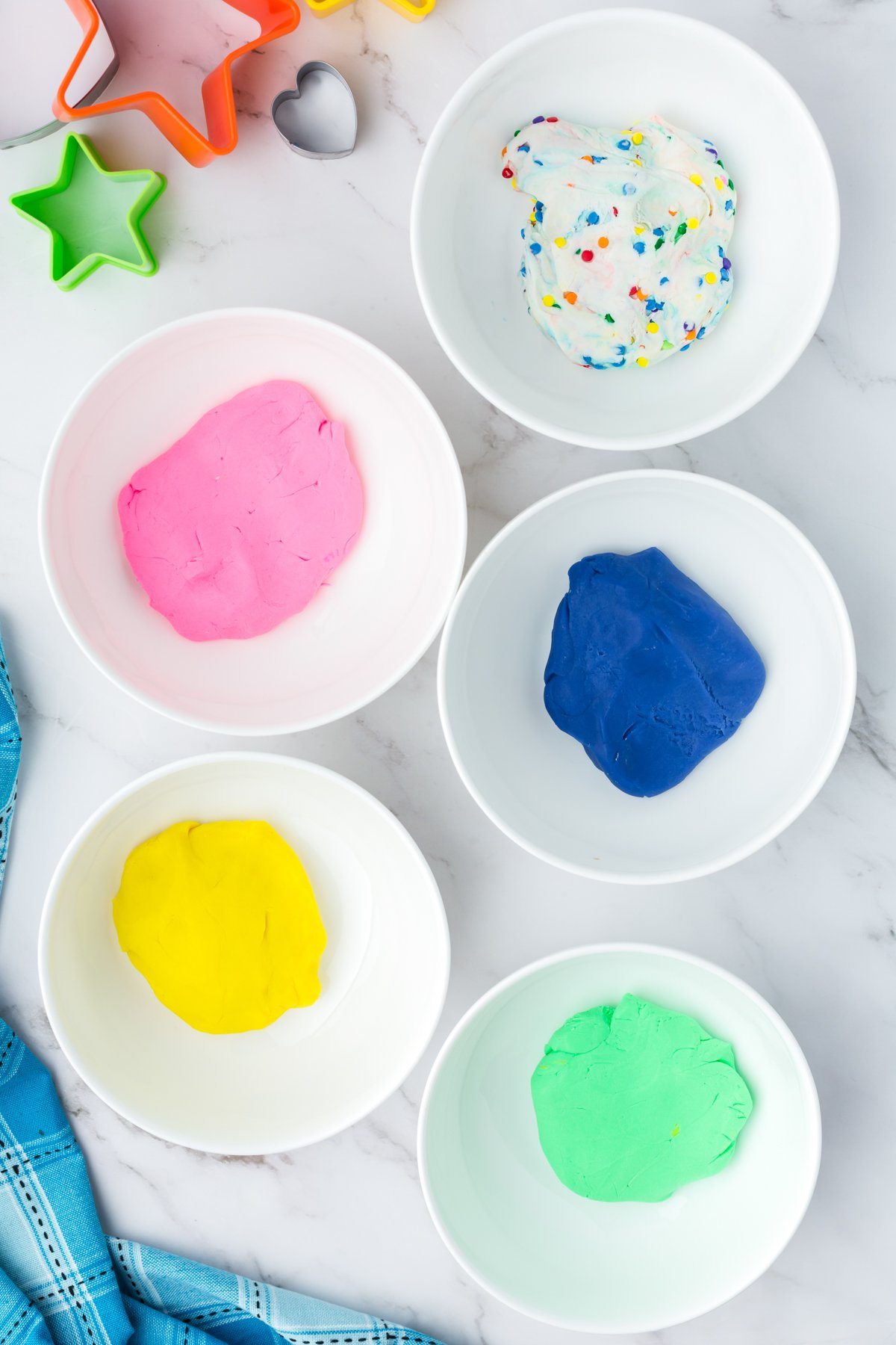 white glass jar with colored edible playdough in them