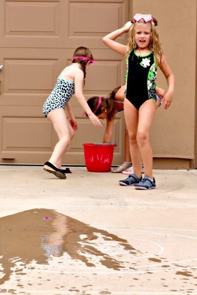 kids tossing water balloons into a chalk bullseye