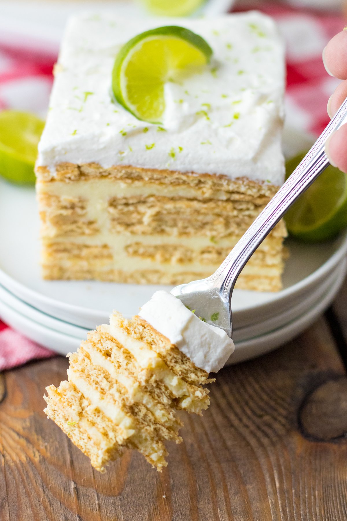 fork full of key lime ice box cake into front of a slice