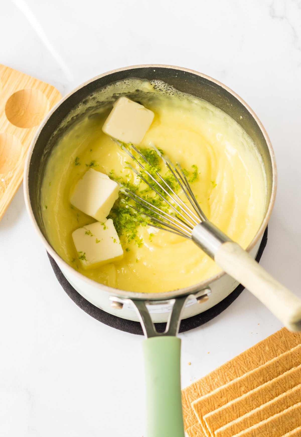 pieces of butter in a key lime curd in a saucepan