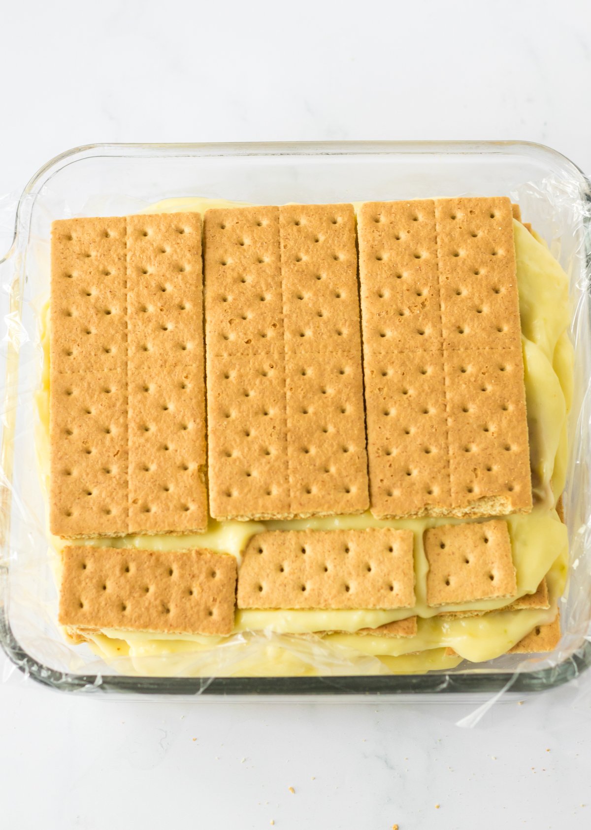 layers of graham crackers and key lime curd in a baking dish