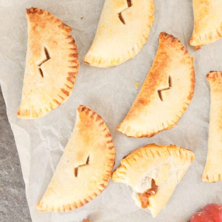 a bunch of pumpkin pasties with lightning bolt slits