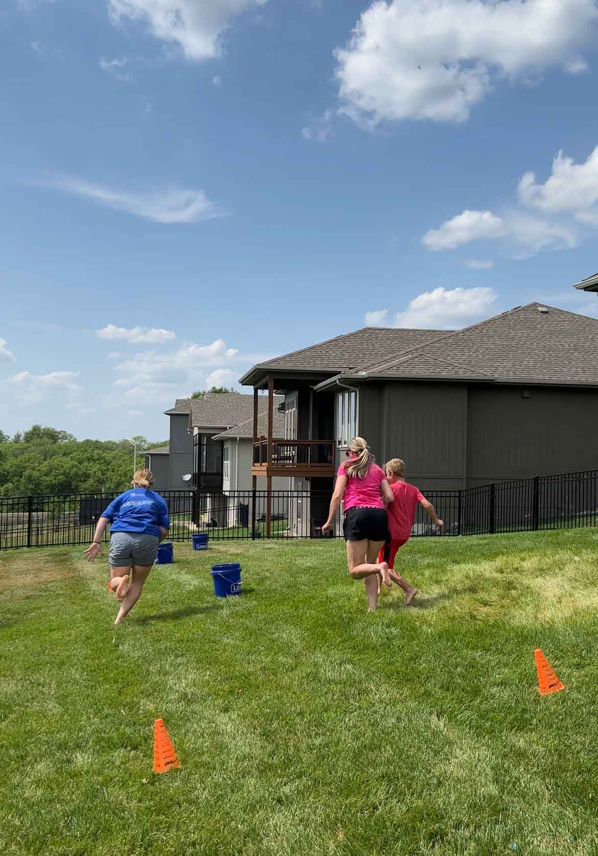 adults running to buckets while playing water balloon games