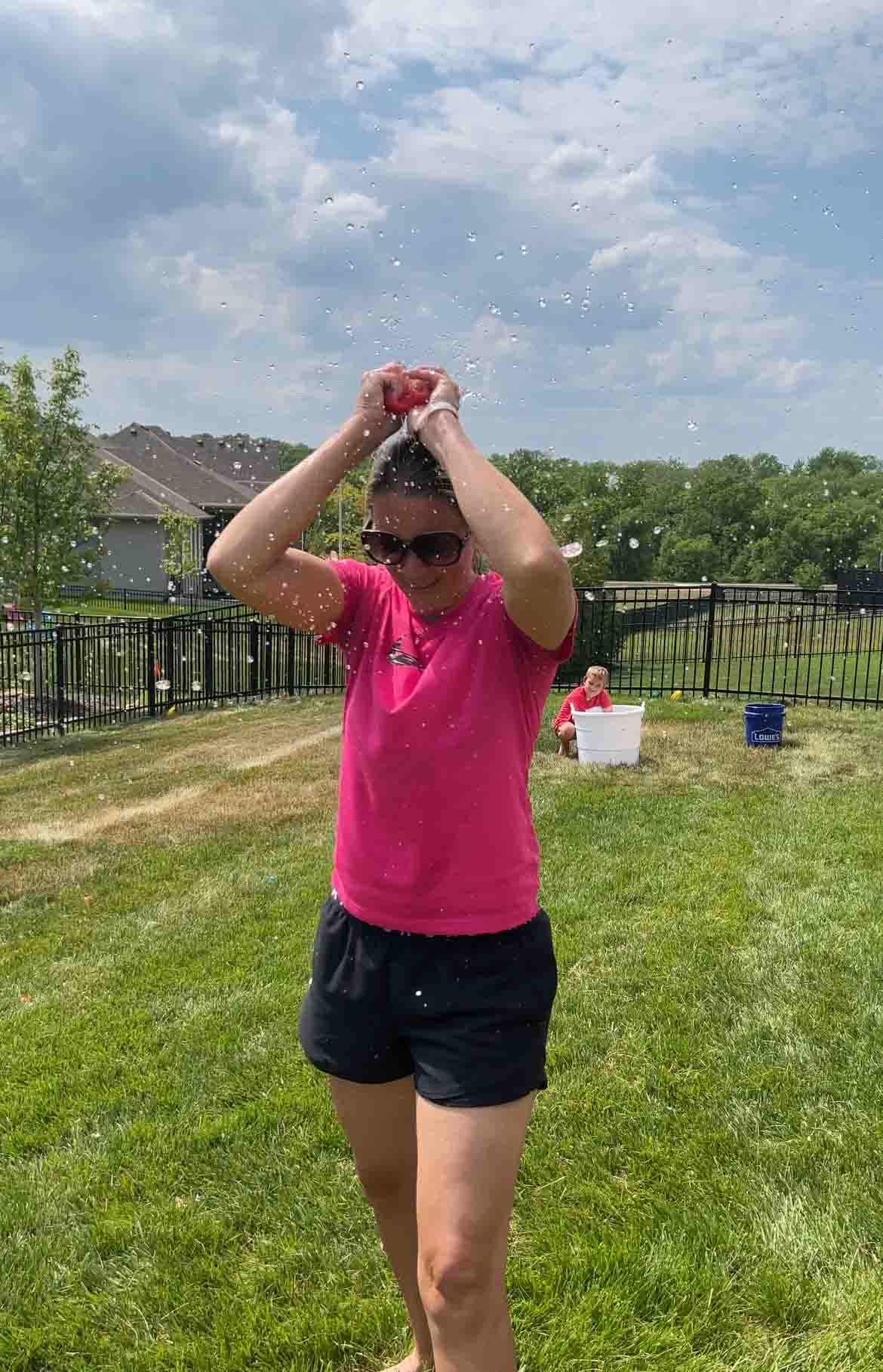 woman breaking a water balloon over her head