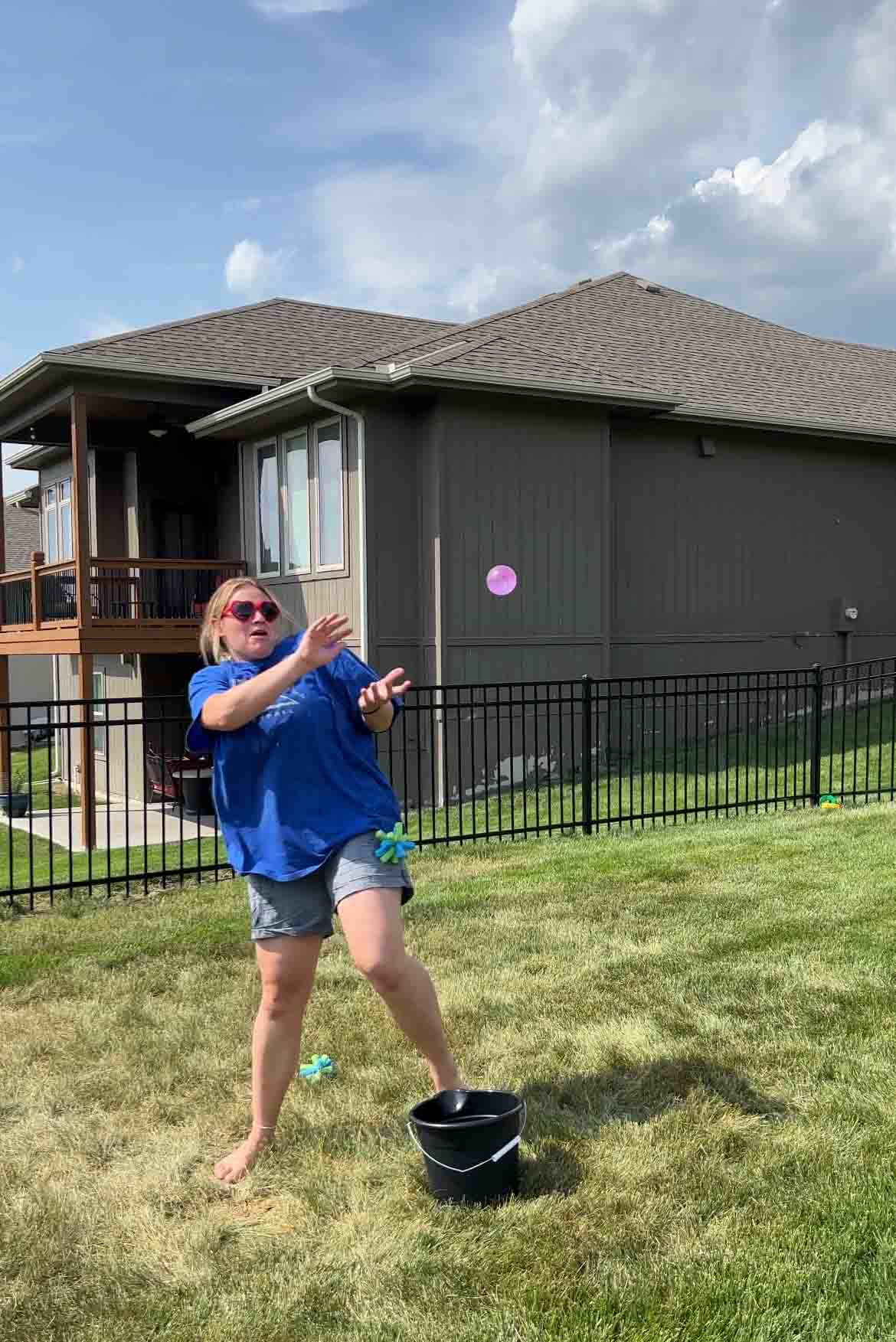 girl getting hit by a sponge while catching a water balloon