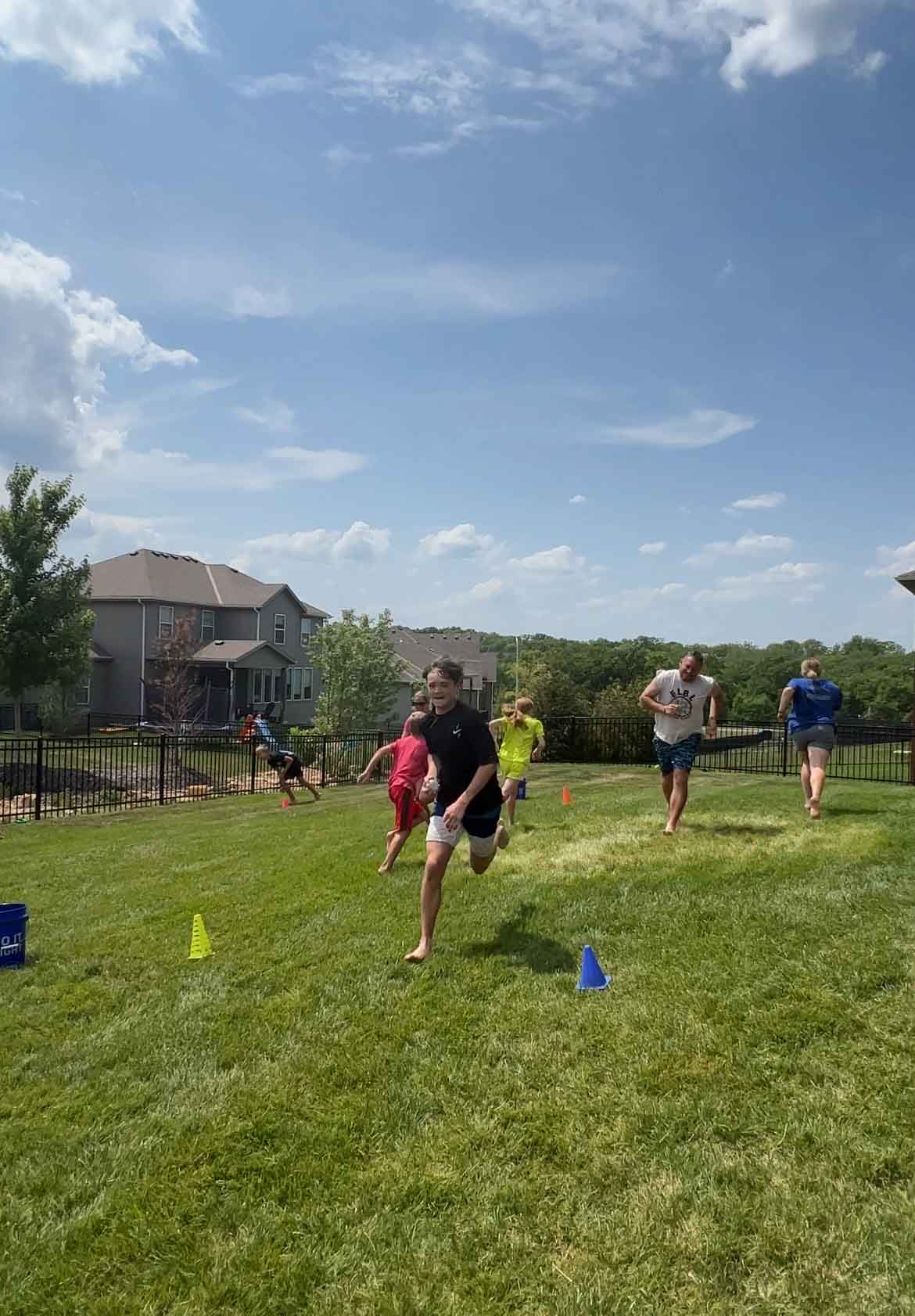kids running through a backyard with water balloons