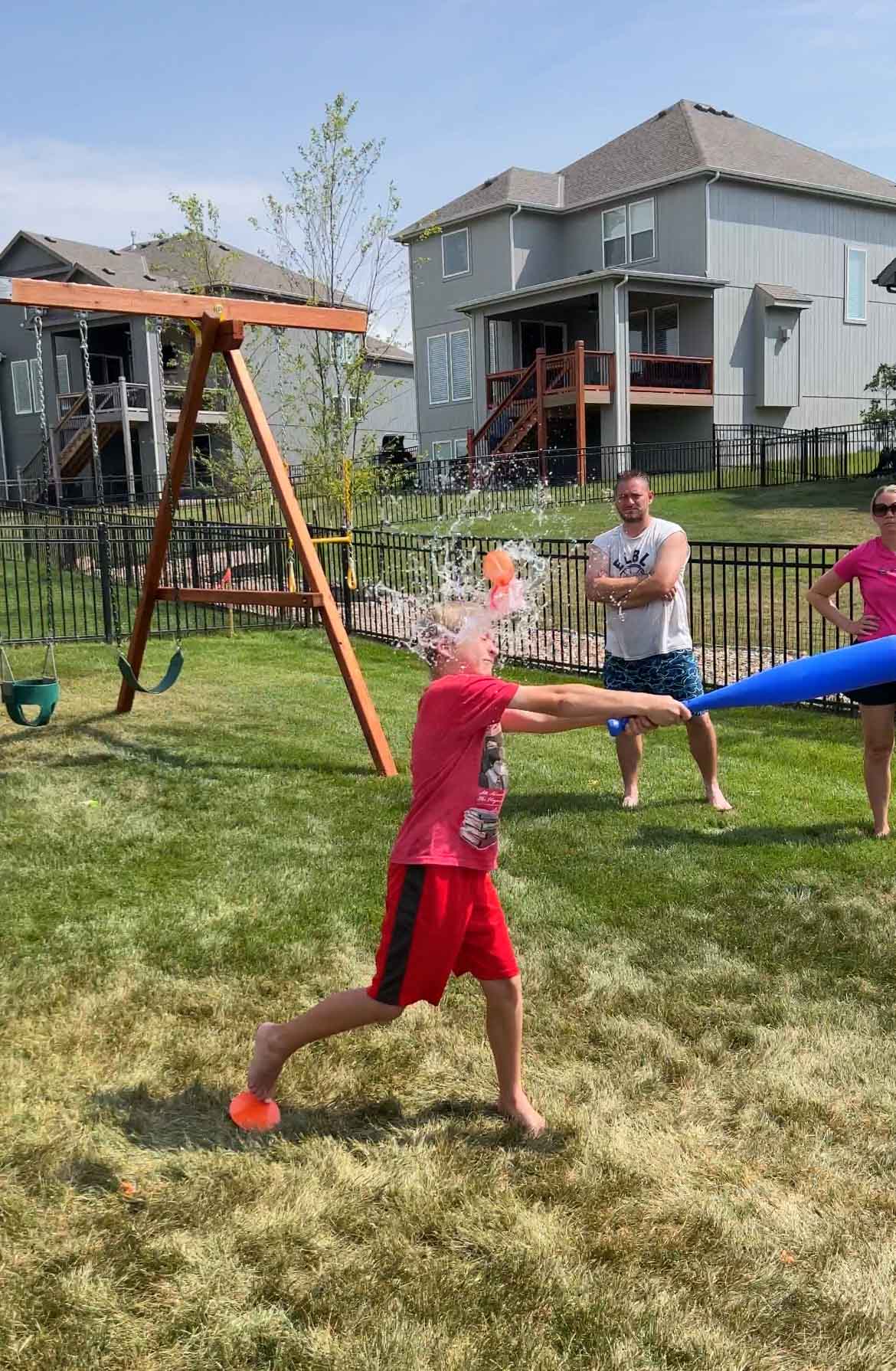 kid hitting a water balloon with a baseball bat