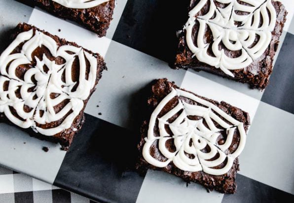 brownies topped with white frosting in spiderweb pattern