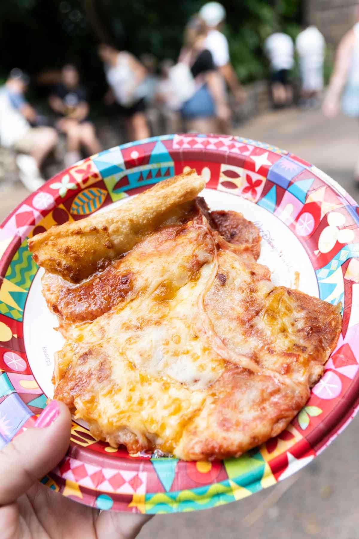 hand holding a slice of pizza