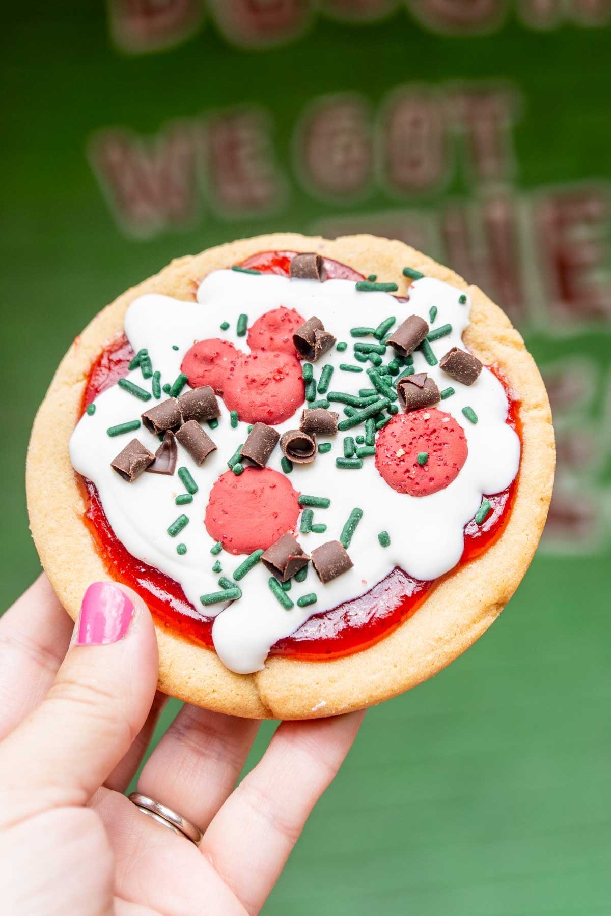 pizza cookie held by a woman's hand