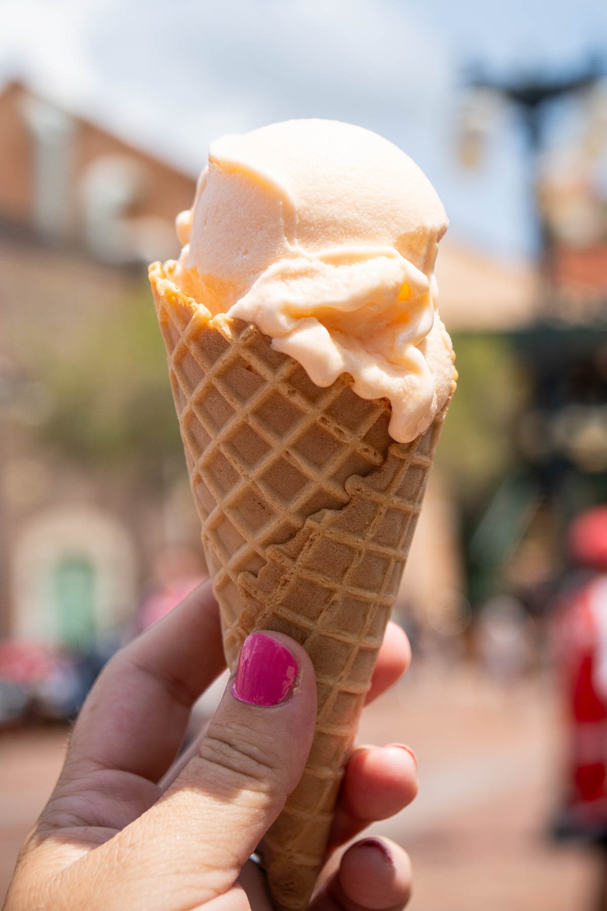 ice cream cone with pog gelato in a woman's hand