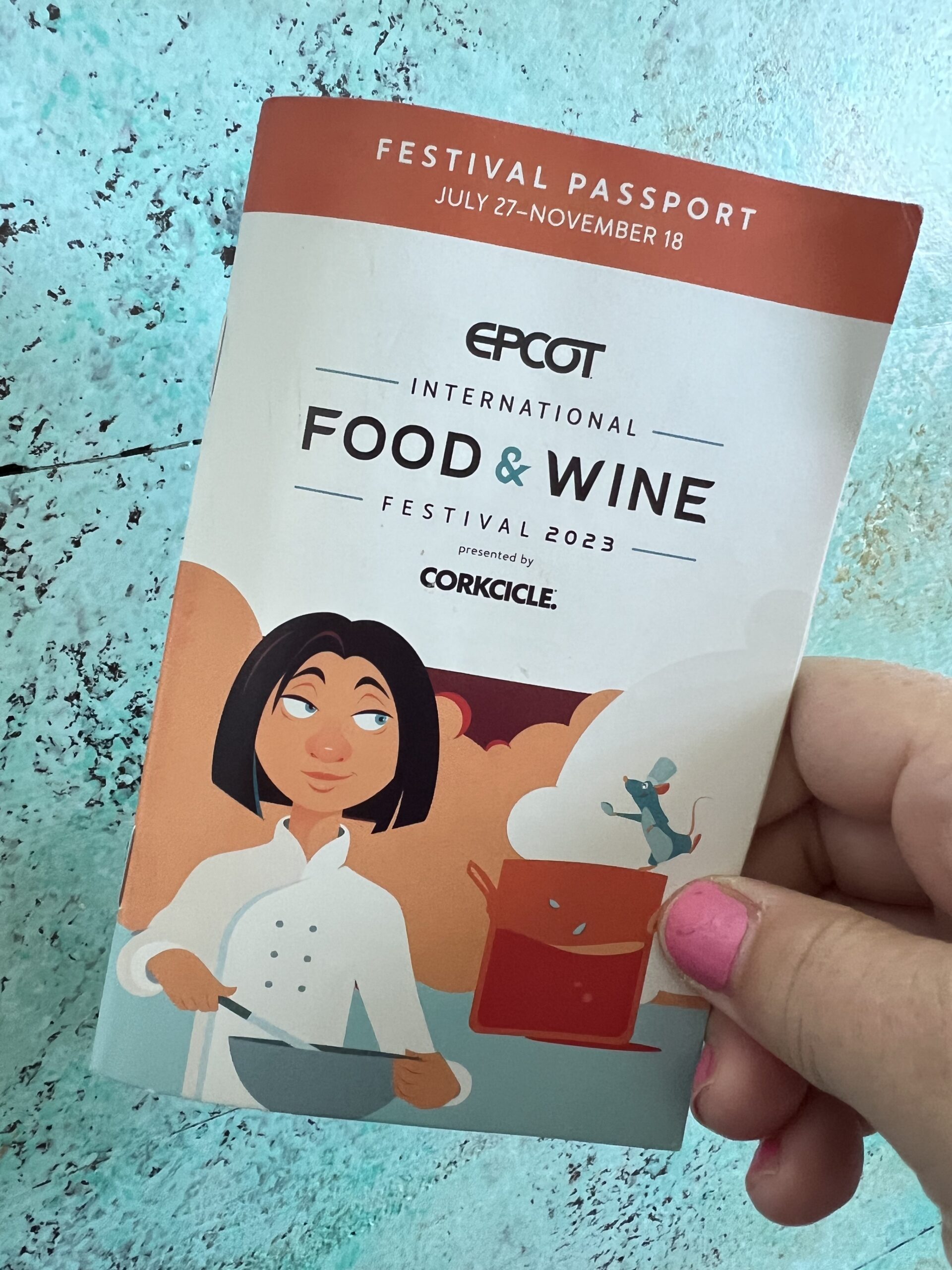hand holding an Epcot food and wine festival menu