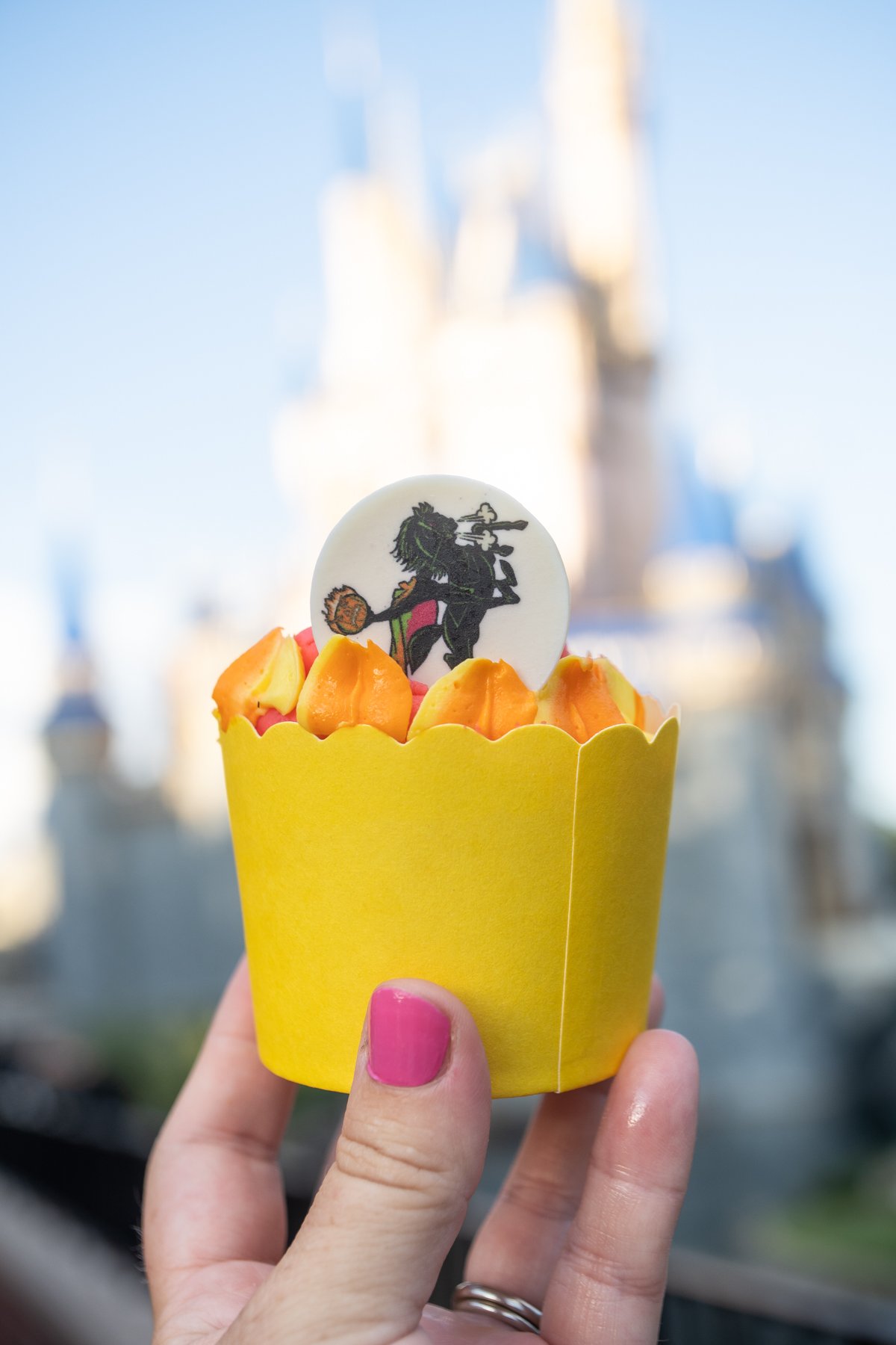 hand holding a headless horseman cupcake