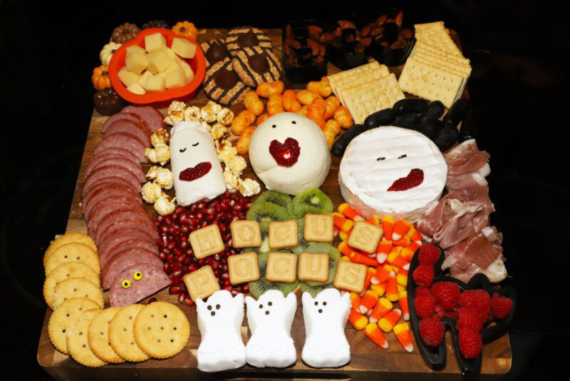 charcuterie board with cheeseballs that resemble the sanderson sisters