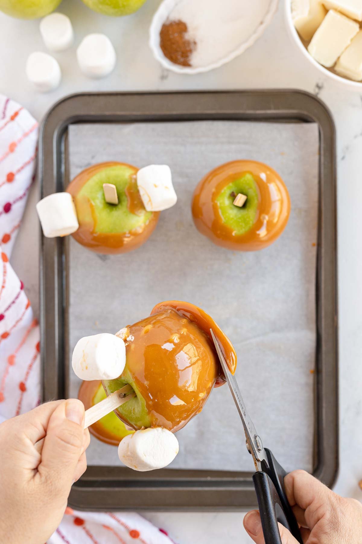 cutting excess caramel off caramel apples