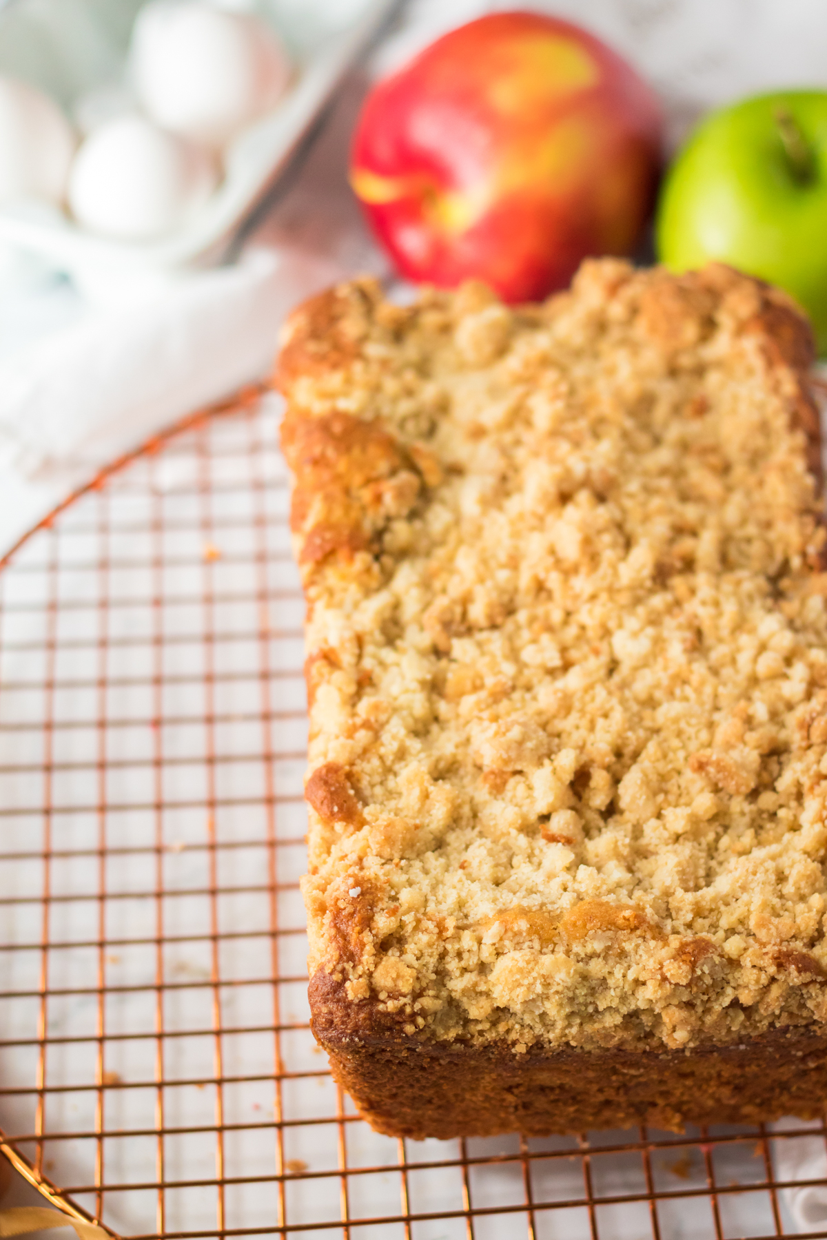 close up view of an apple streusel cake on a drying rack