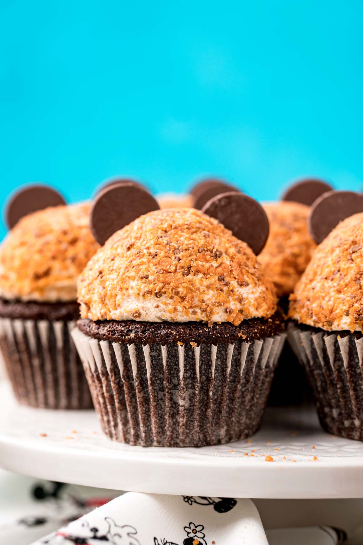 Butterfinger cupcakes on a white cake stand