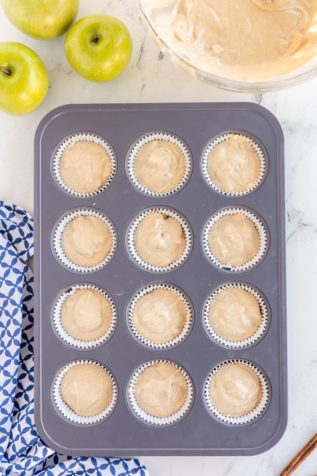 muffin tin with unbaked caramel apple cupcake batter