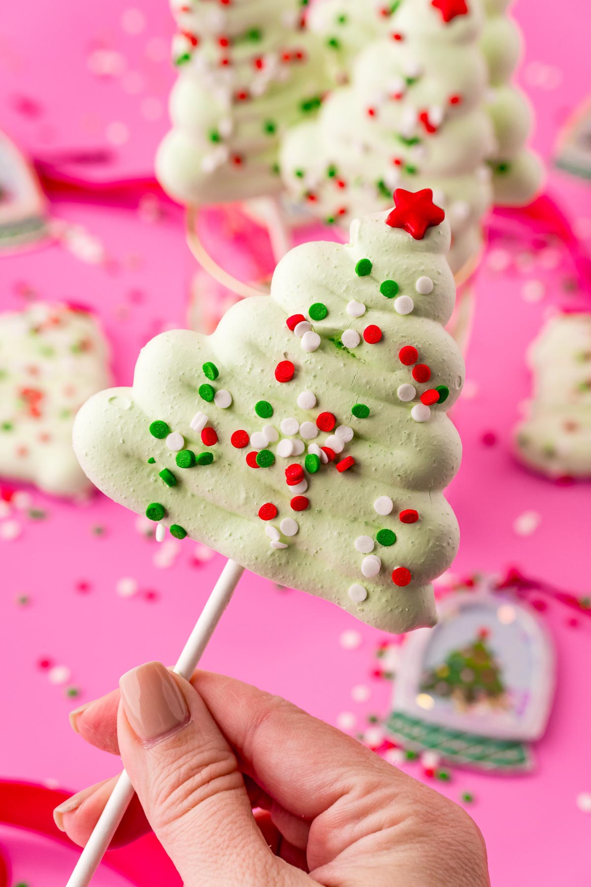 hand holding a Christmas meringue tree pop 