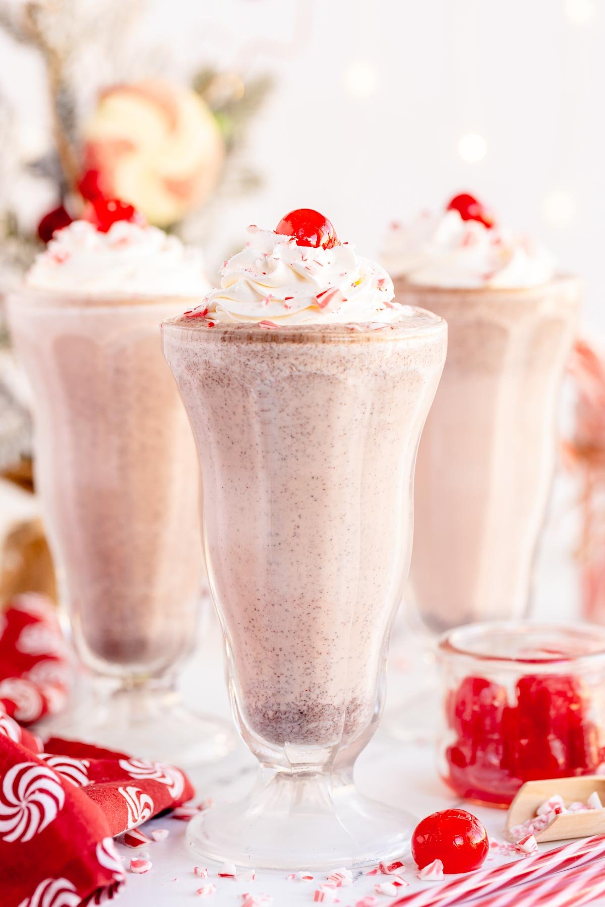 three peppermint milkshakes in milkshake glasses