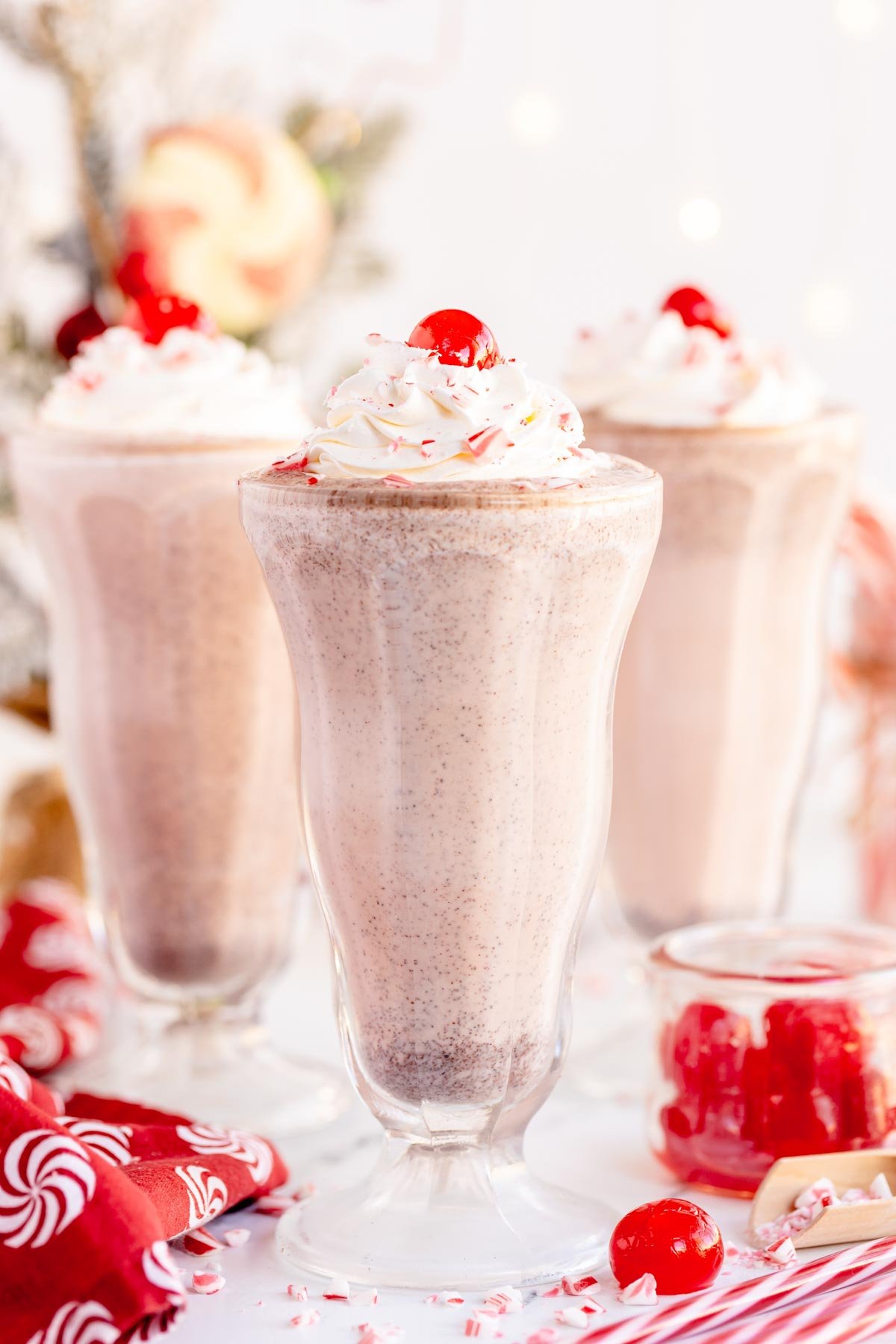 three peppermint milkshakes in milkshake glasses