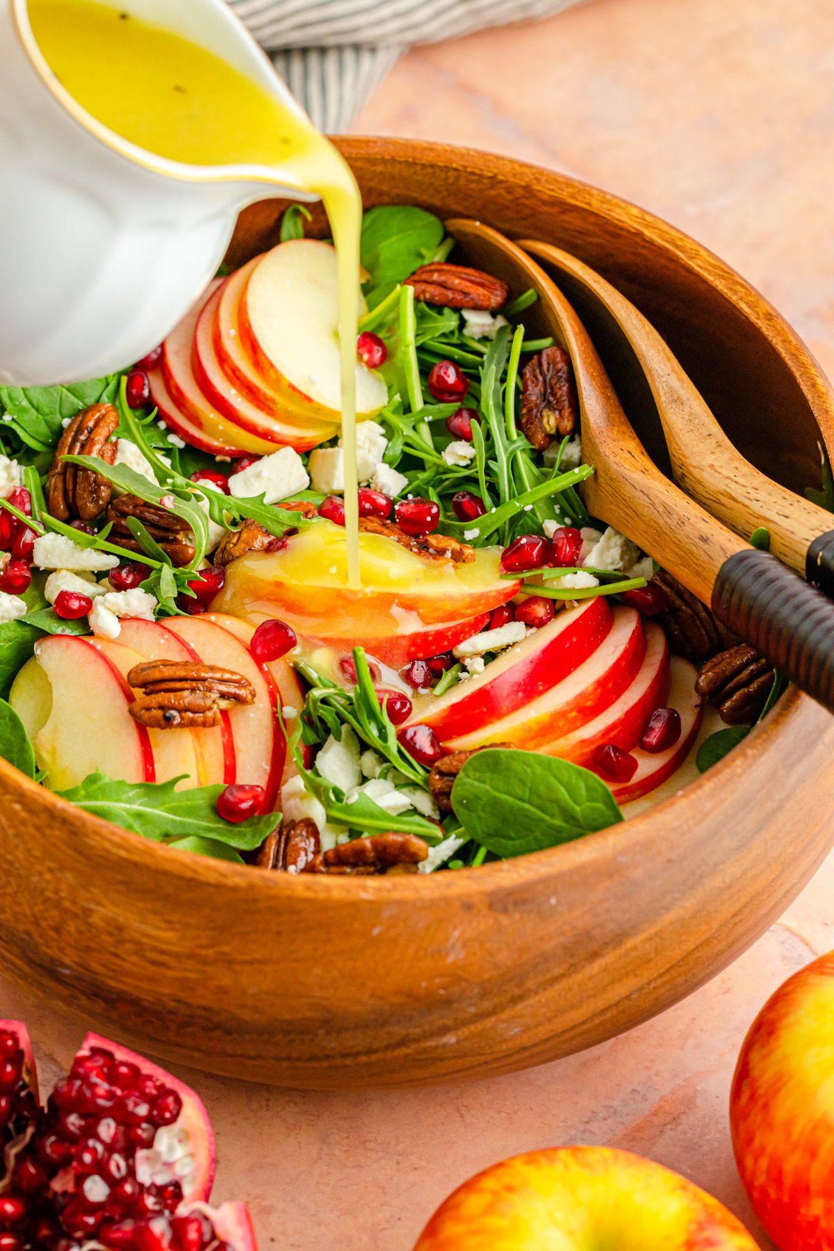 pouring dressing on a pomegranate feta salad