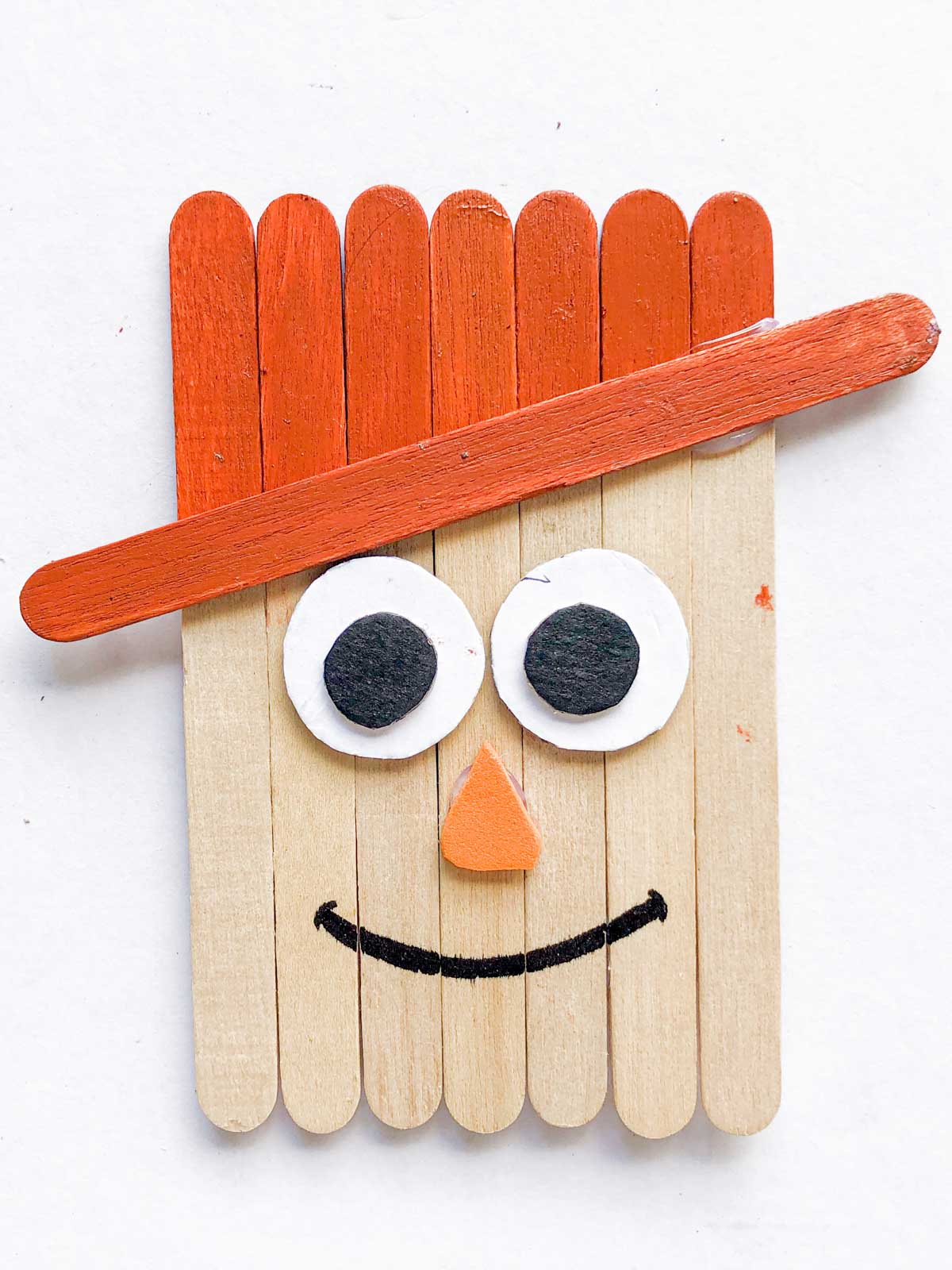 popsicle stick scarecrow with an orange hat